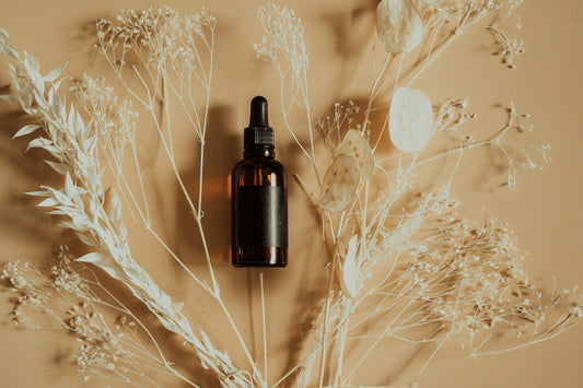 Banner featuring natural essential oil bottles surrounded by plants and wellness tools, representing pure essential oils for holistic health and wellness.